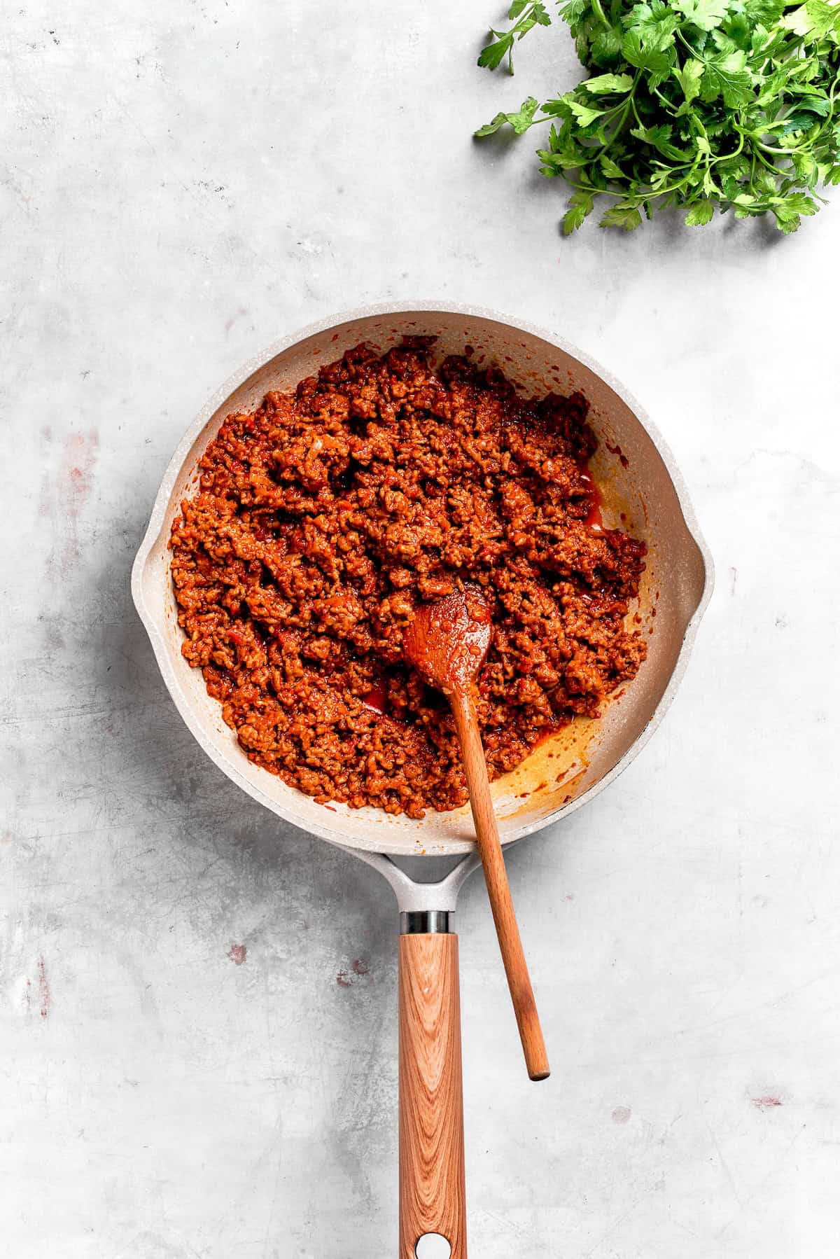 The beef filling mix for Dorito casserole in a skillet.