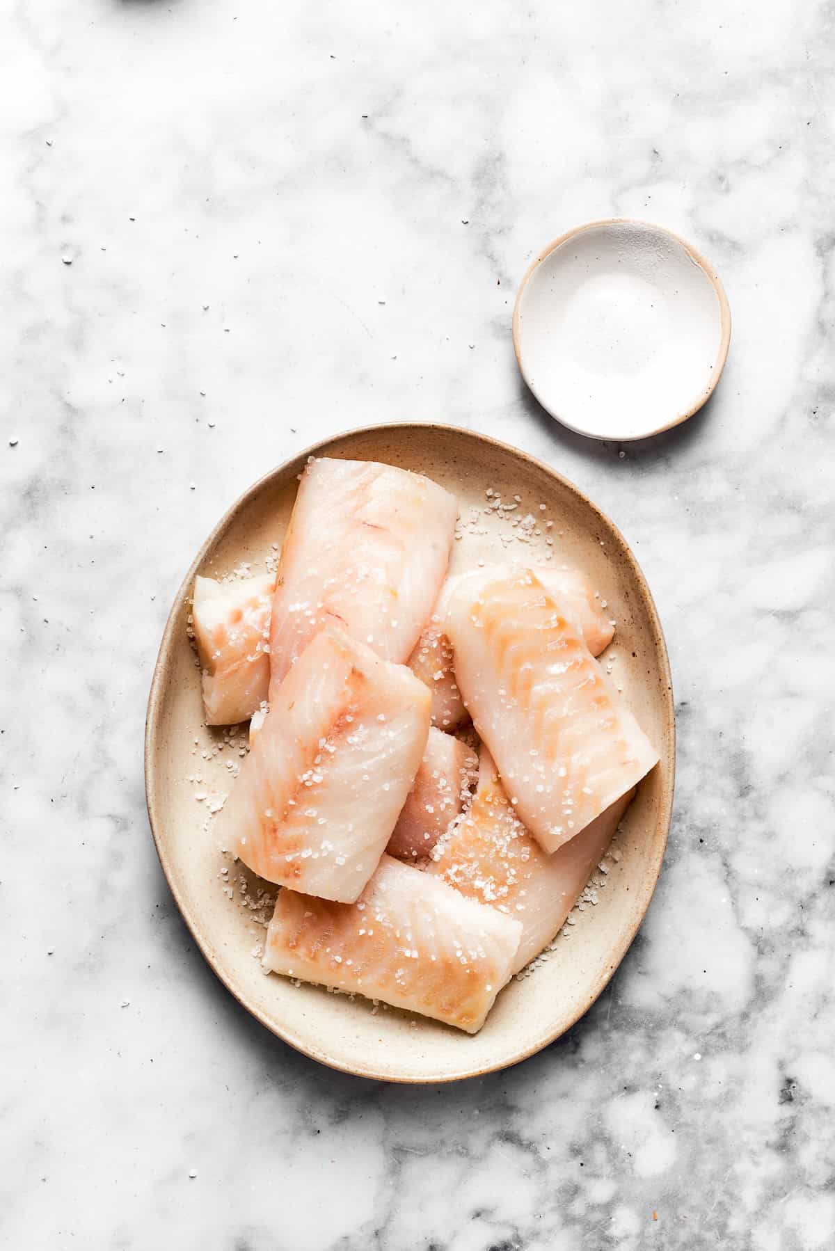 Pieces of white fish on a plate.