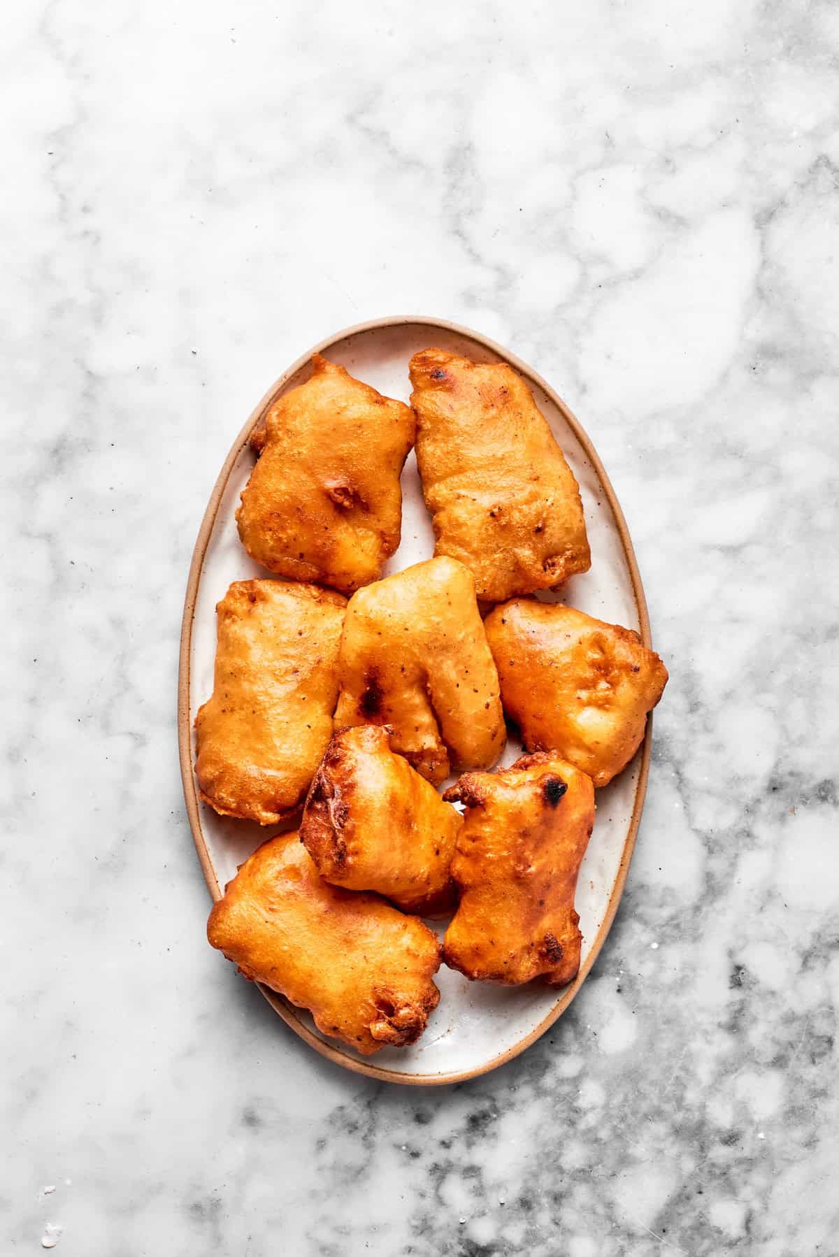 Fried pieces of fish on a plate for a fish sandwich.