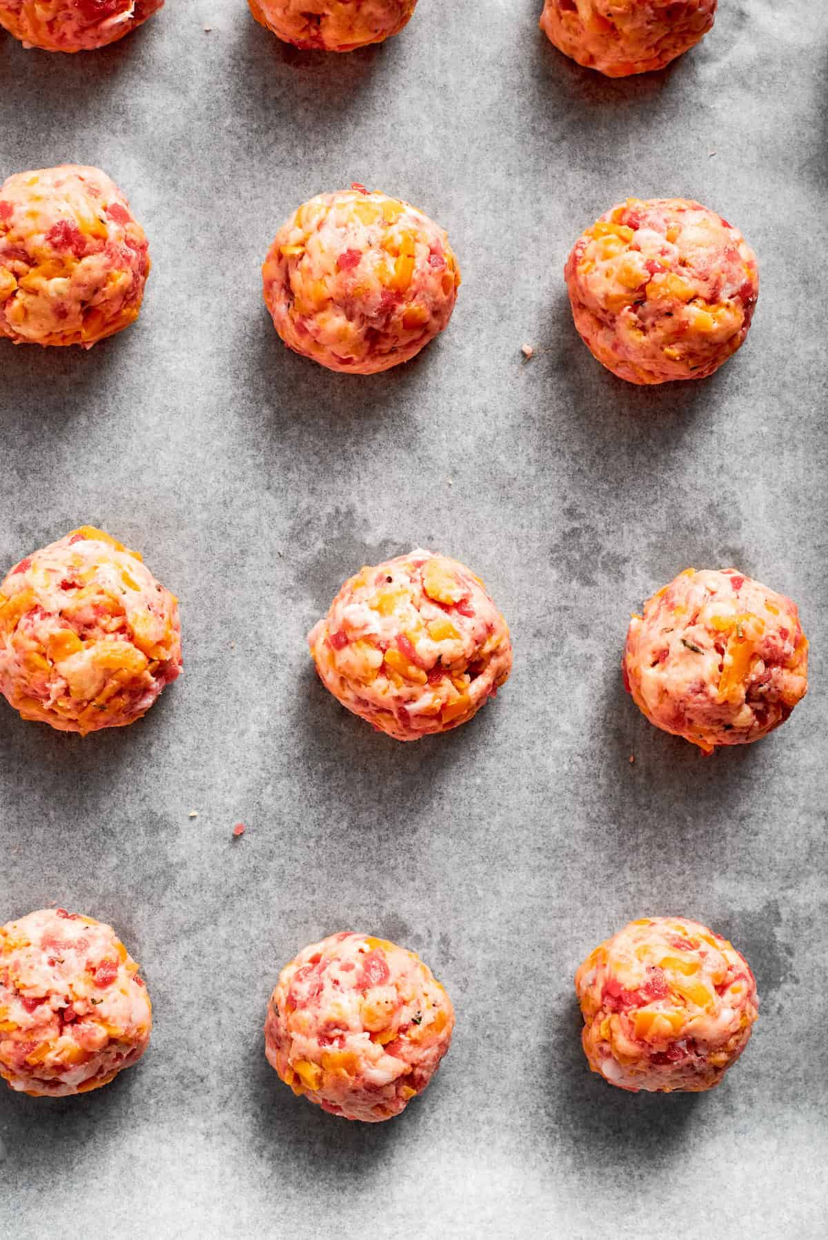 Sausage balls on a line baking tray.