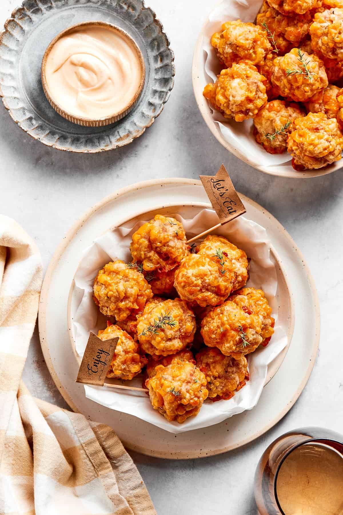 This sausage balls recipe relies on Bisquick, pork sausage, and Italian seasoning for an easy appetizer. Don't forget the dipping sauce! Bowls of sausage balls and dip.
