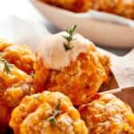 Dipping sauce tops a sausage ball.