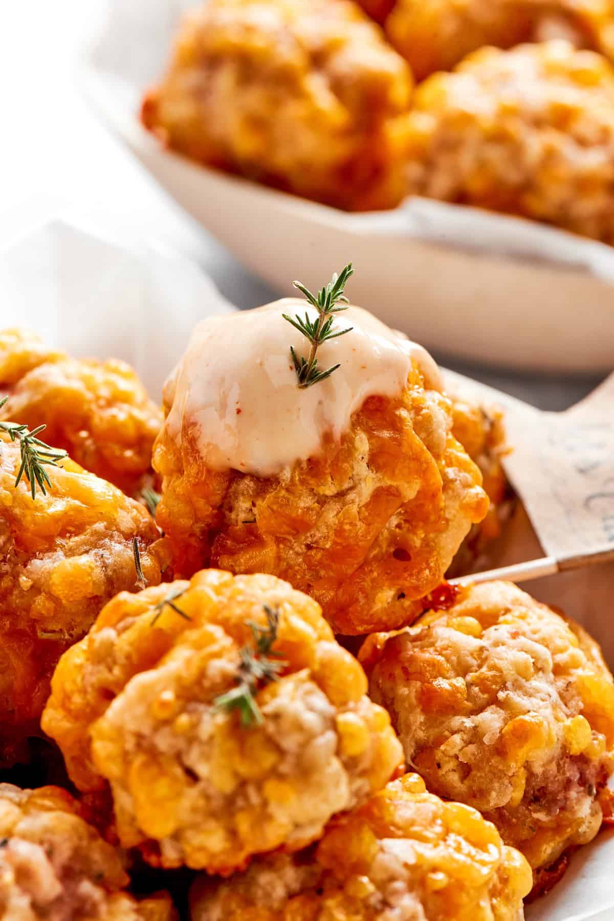 Dipping sauce tops a sausage ball.