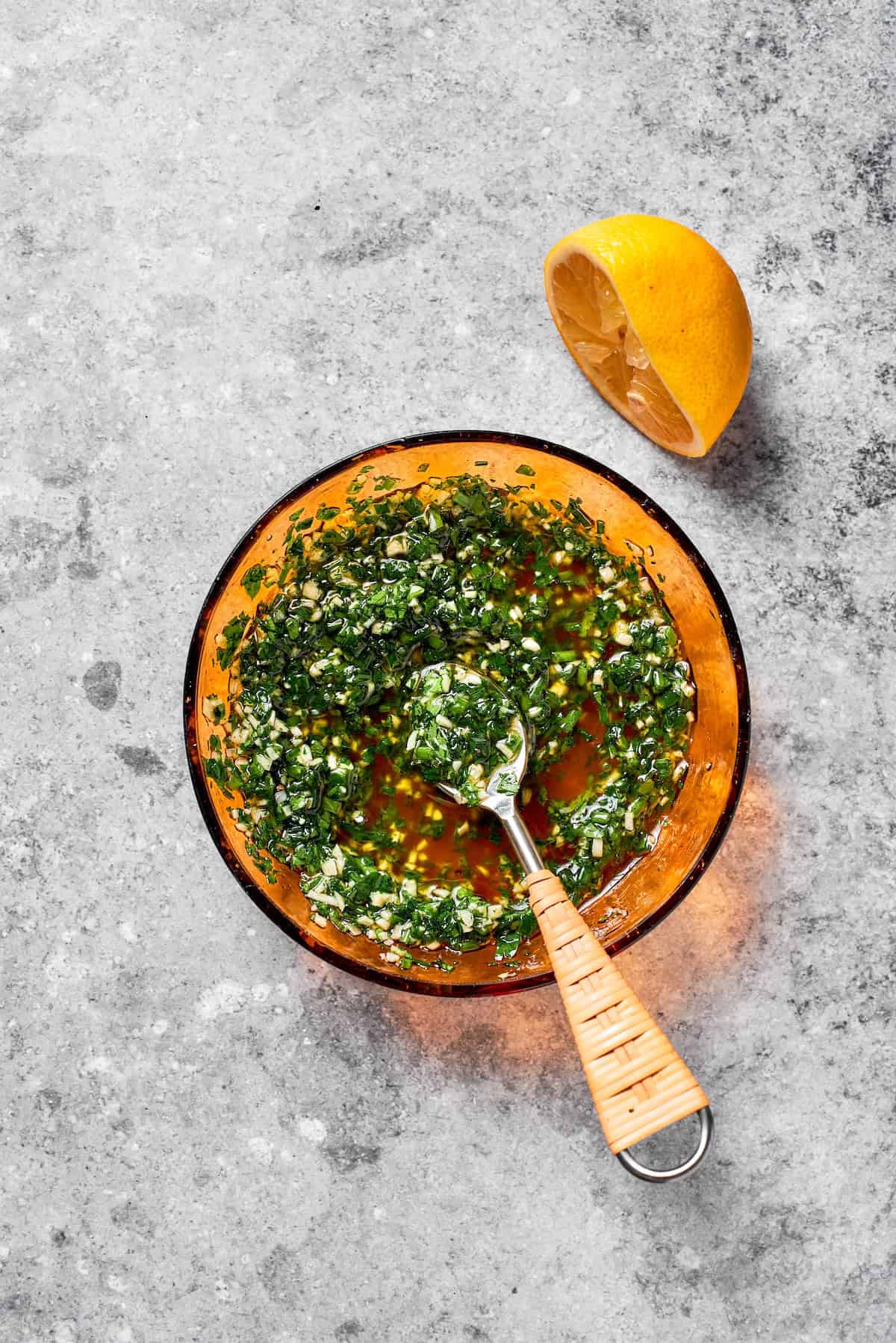 Herb sauce is stirred in a bowl.