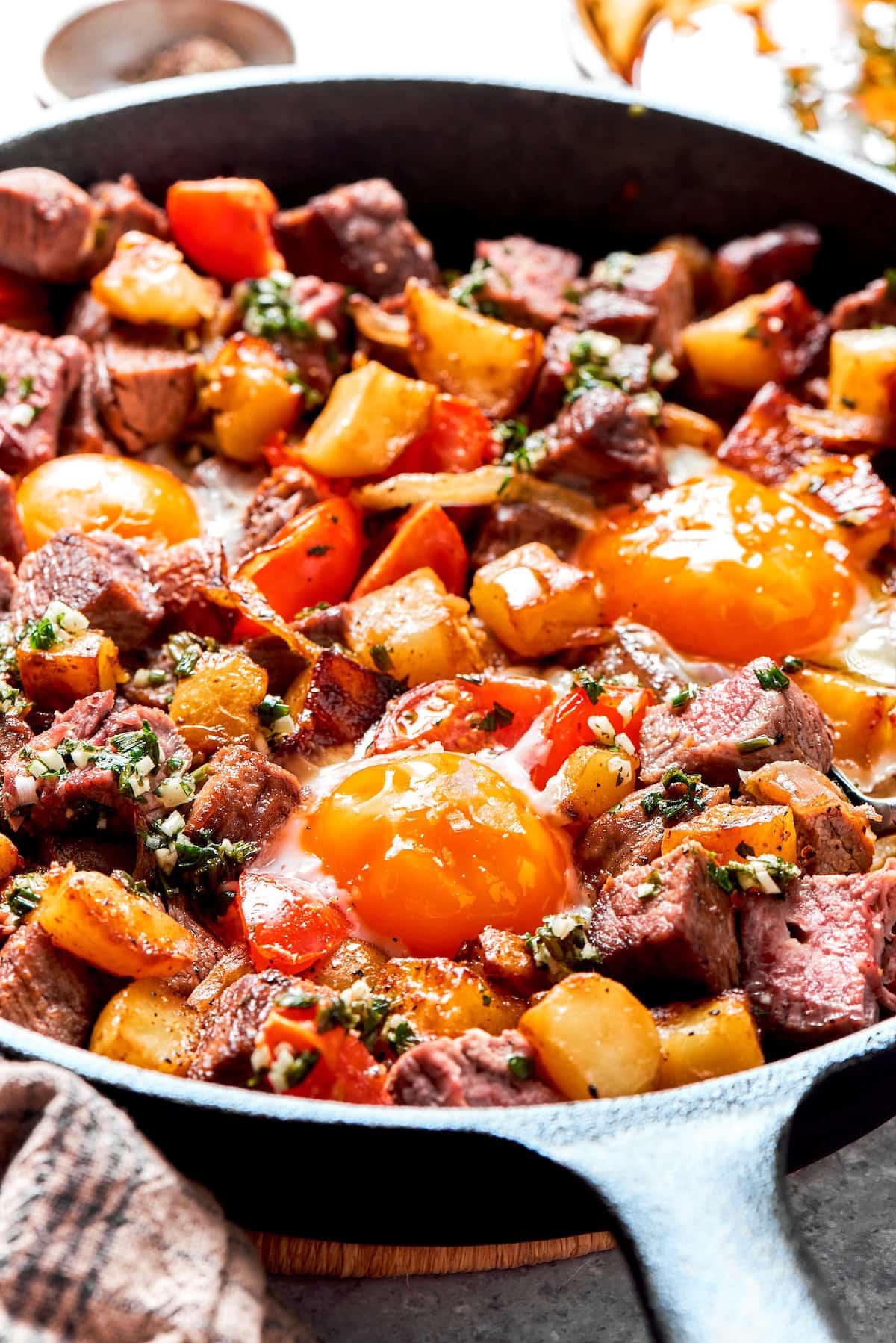 Fried eggs on top of a pan of steak and eggs.