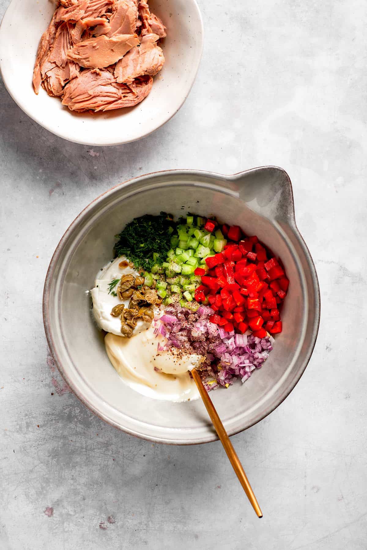 Vegetables and other ingredients in a bowl for tuna melt filling.