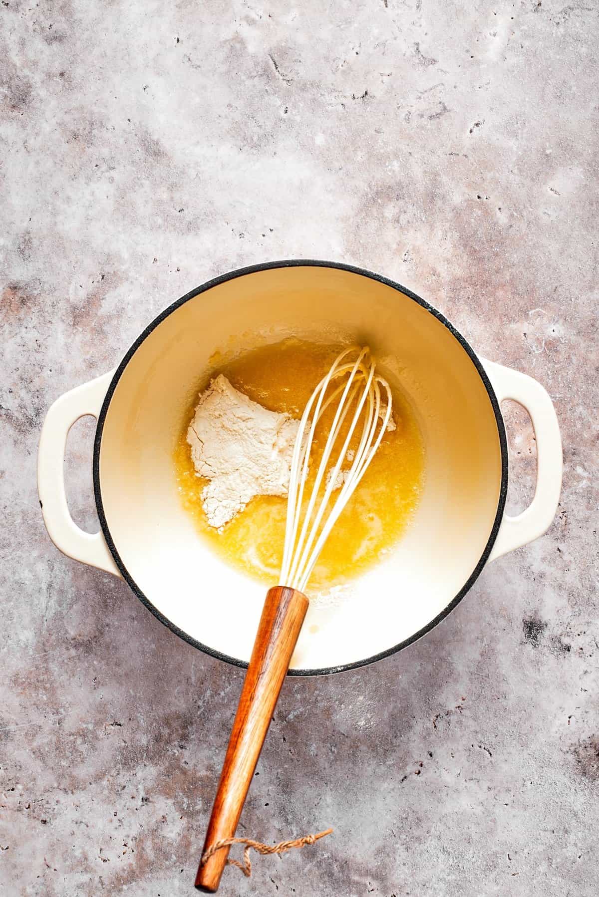 Butter and flour are combined in a pot to make a roux.