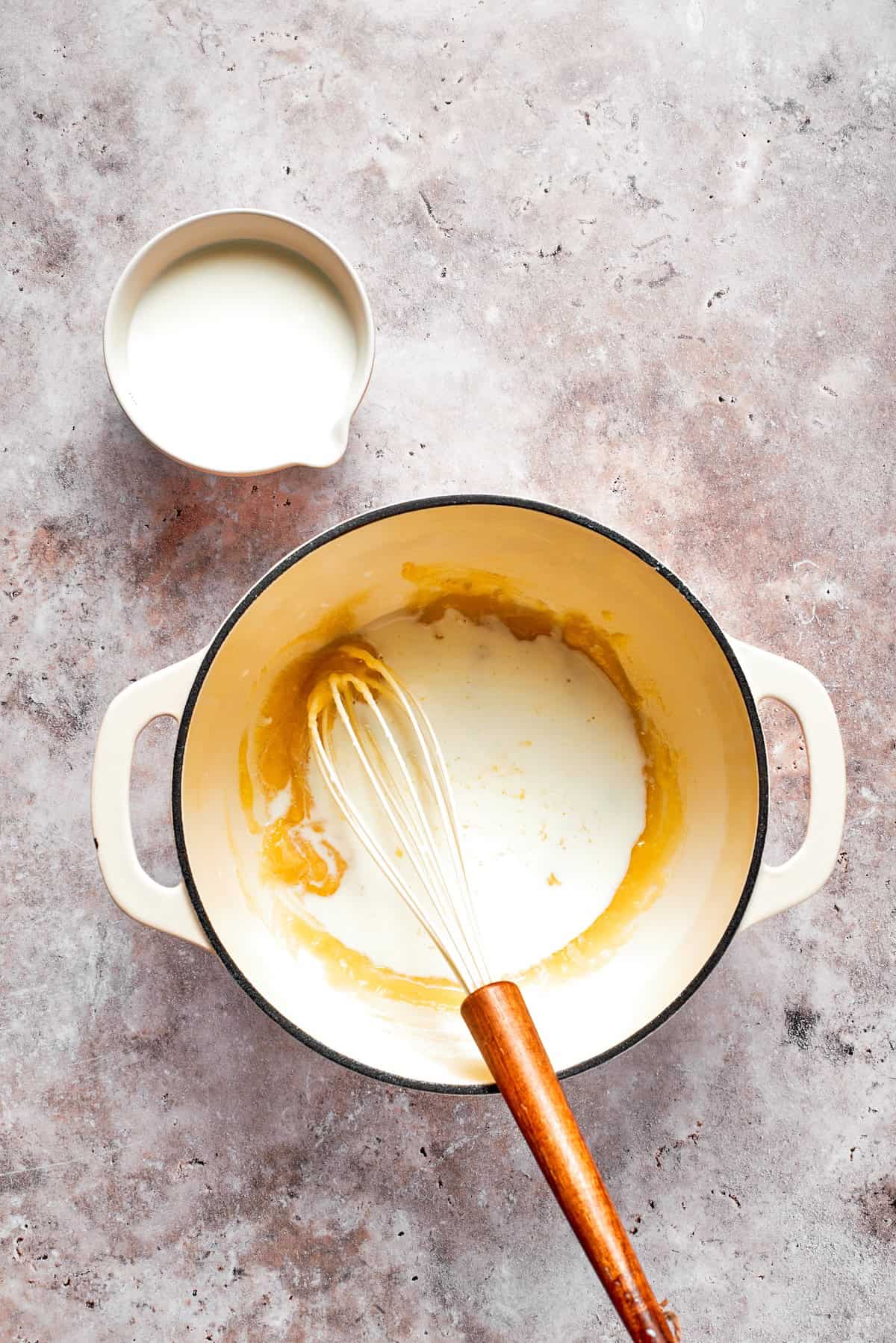 Cream is whisked into a roux.