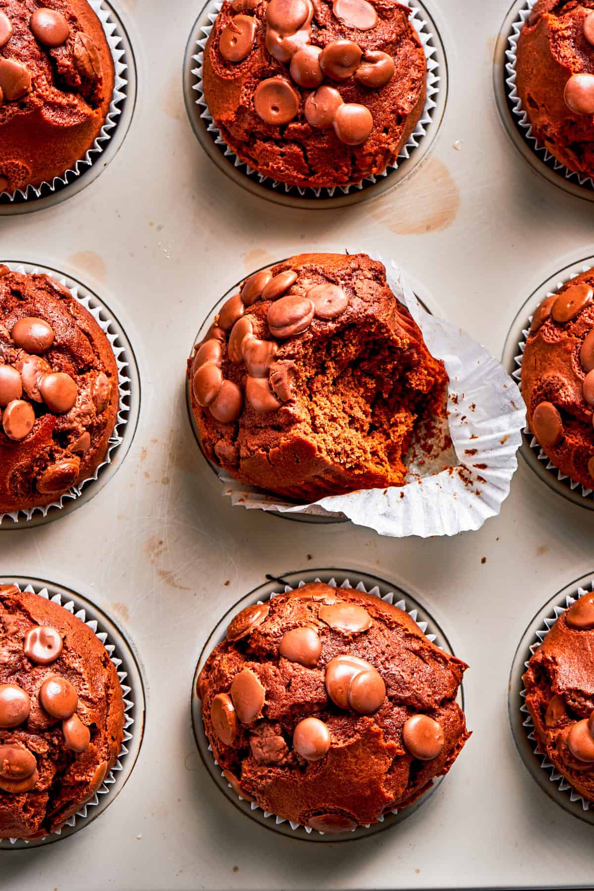 This moist and tender chocolate muffins recipe creates gorgeously high-domed muffins studded with chocolate chips. Go ahead and indulge! Chocolate muffins in muffin liners.