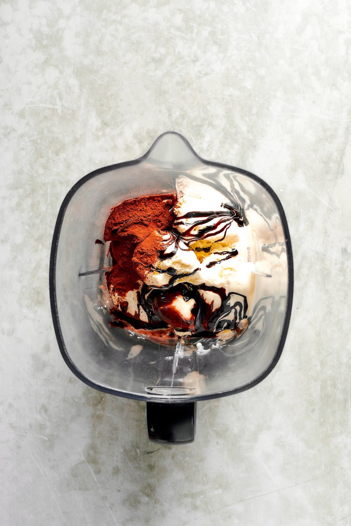 Ingredients for chocolate milkshakes are added to a blender.