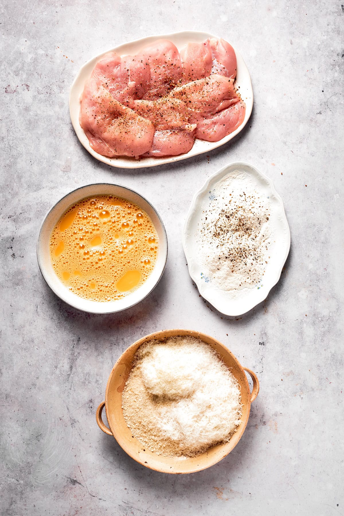 Bowls of dredging material and a plate of chicken.