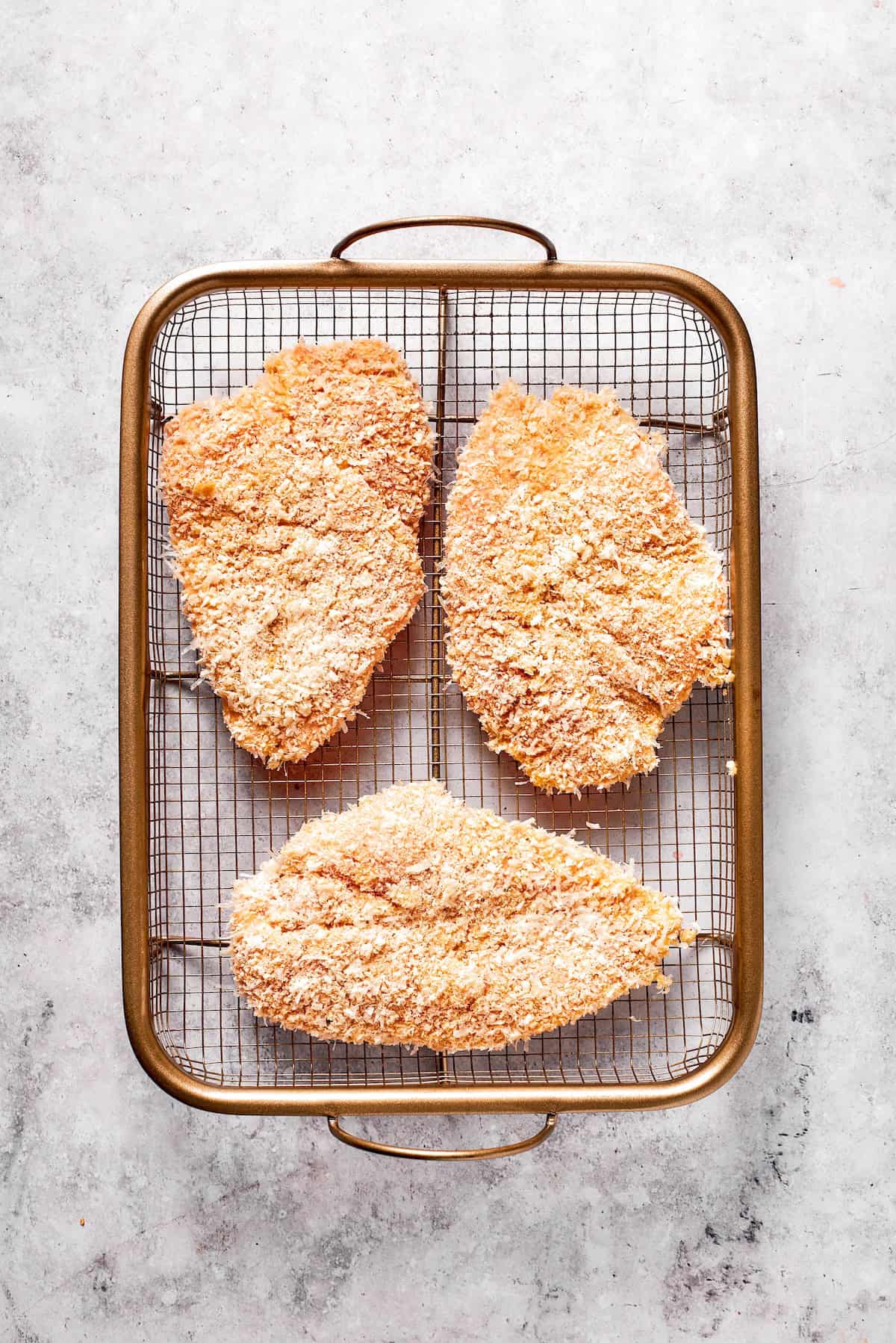 Three pieces of breaded chicken for crusted chicken romano.