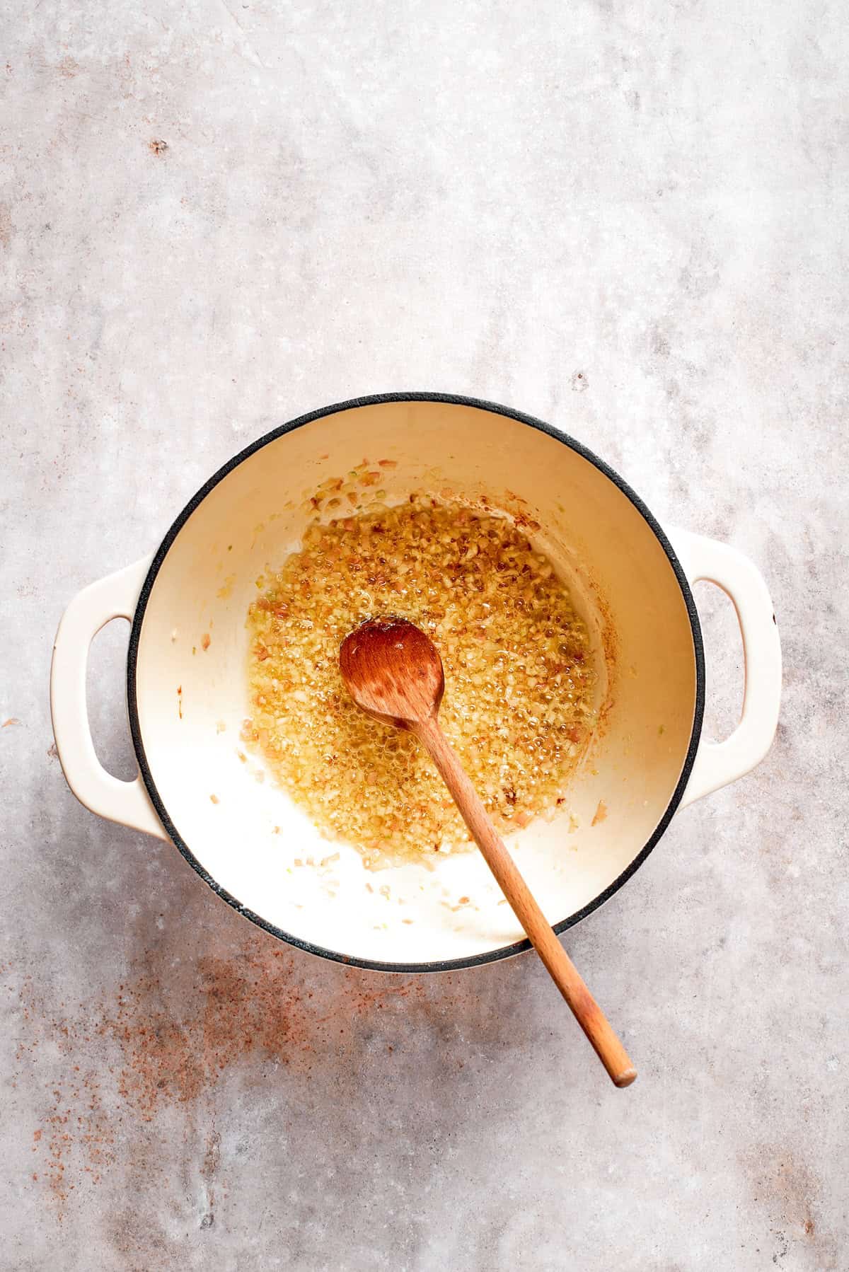Aromatics are sauteed in a soup pot.