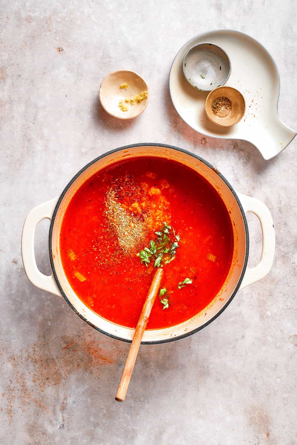 Herbs are added to tomato florentine soup.