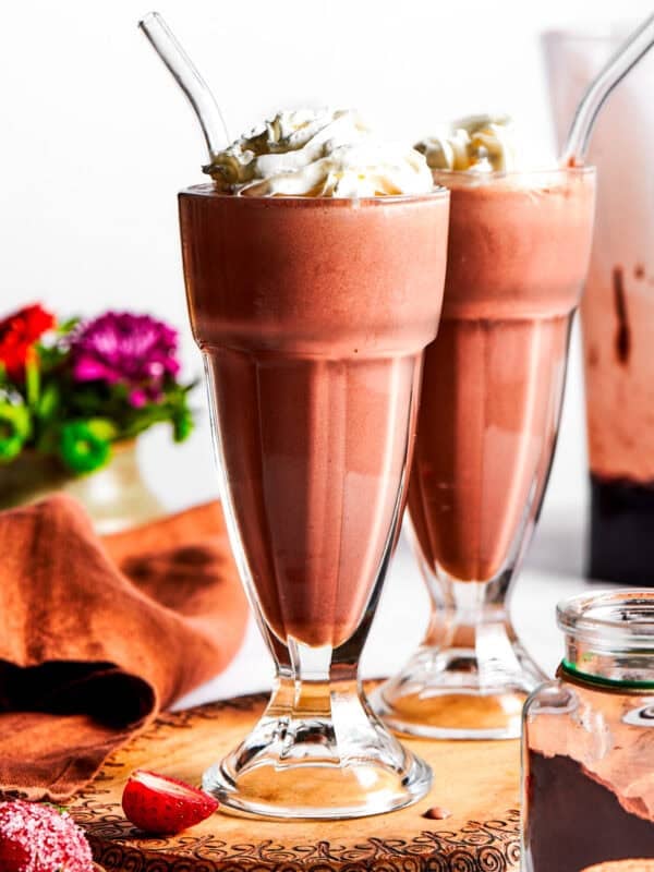 Chocolate milkshakes topped with whipped cream.