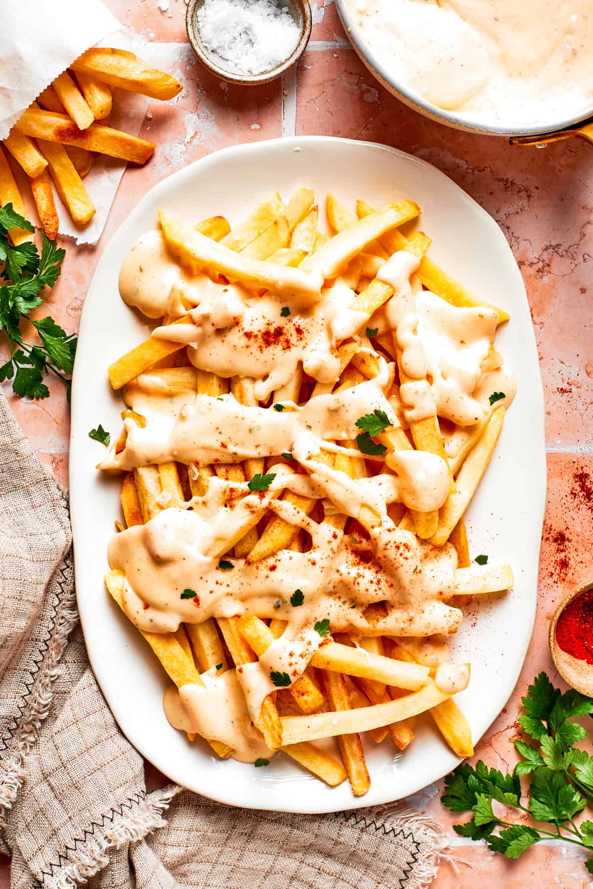 Voodoo fries served on an oval platter and topped with cheese sauce.