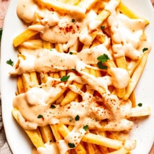 A platter of voodoo fries topped with cheese sauce.