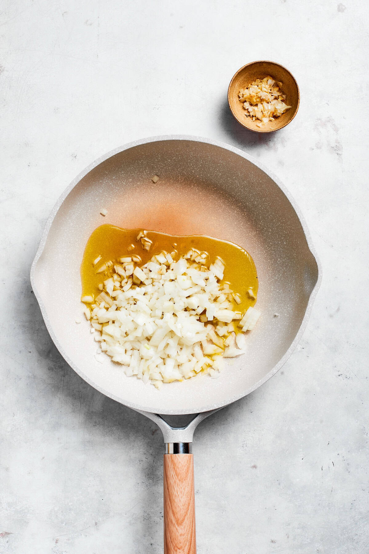 Garlic and onion cook in a skillet.