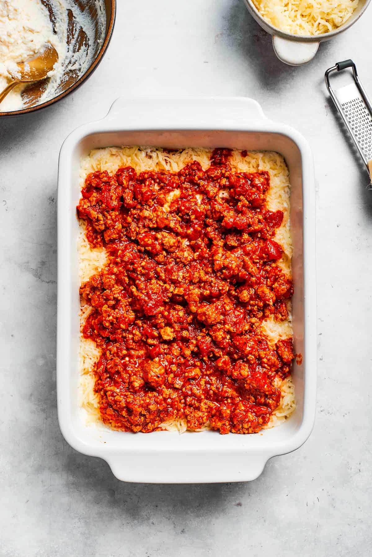 Meat sauce is added to beef lasagna.