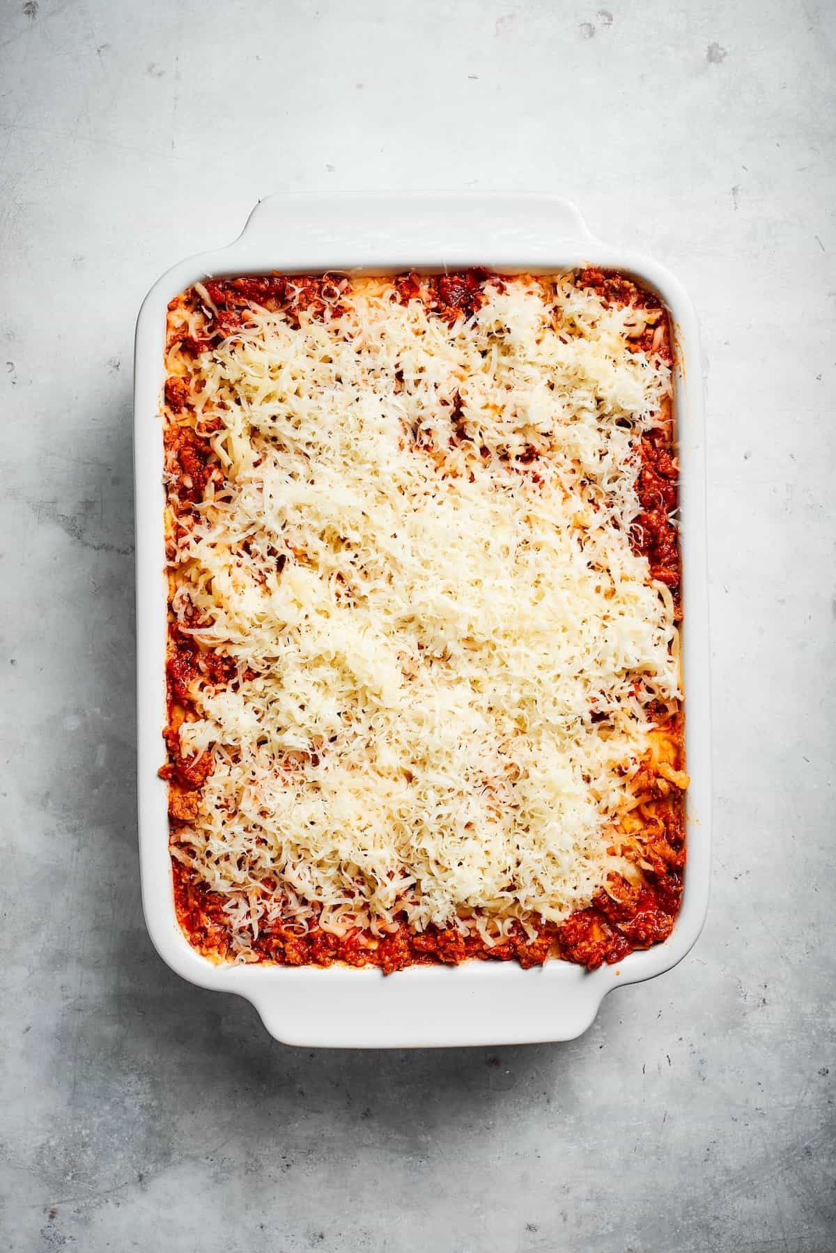 Cheese on top of a pan of beef lasagna.