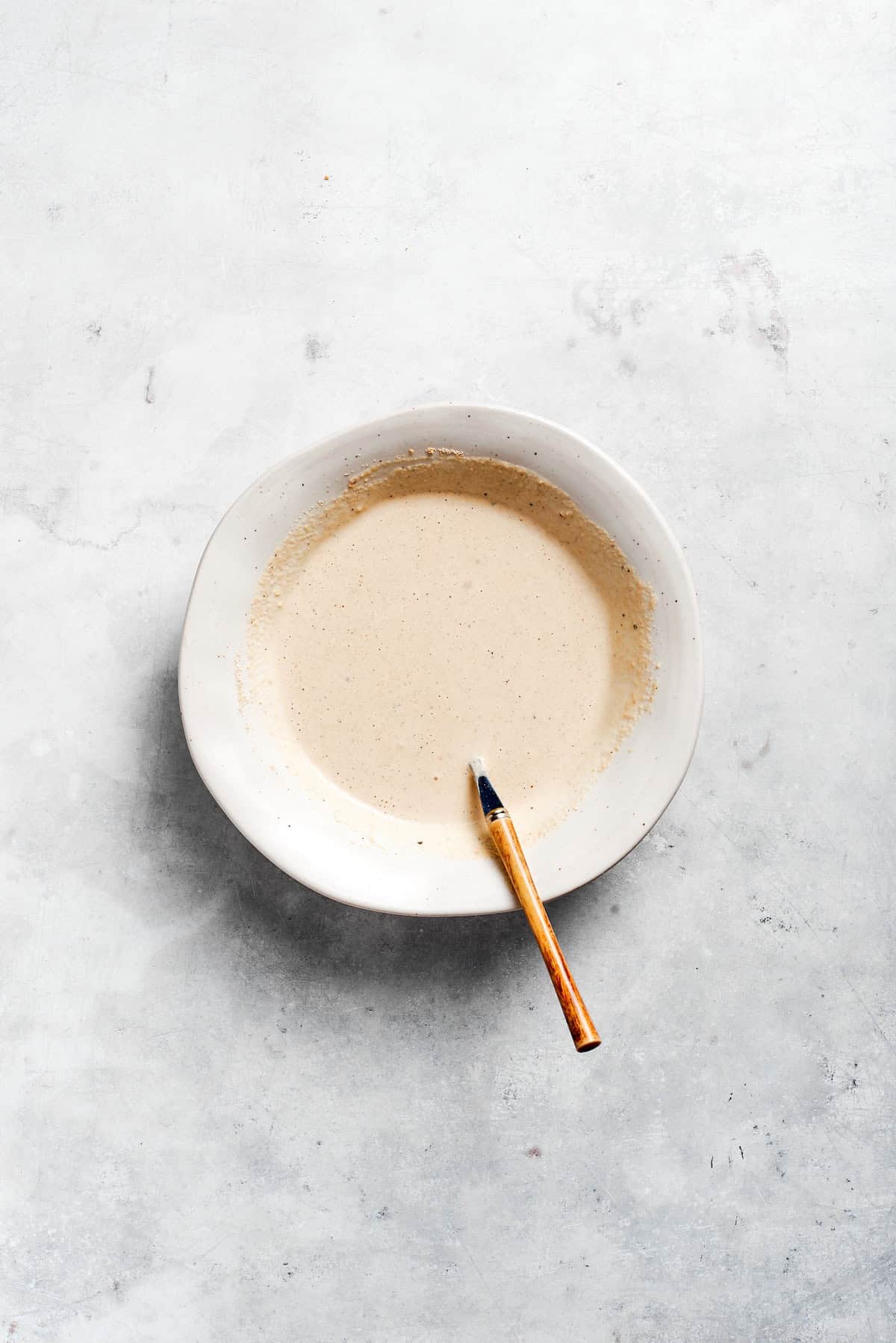 Caesar dressing mixed in a bowl.