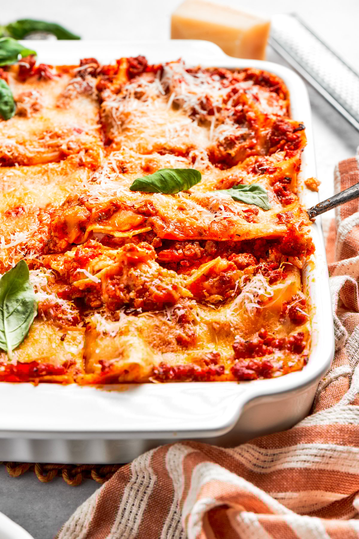 Lifting out a slice of lasagna from a baking dish.