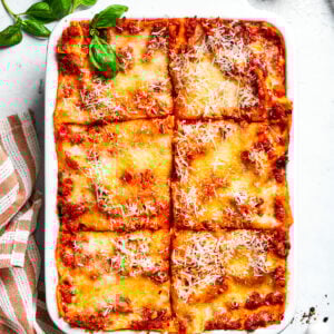 A pan of beef lasagna cut into squares.
