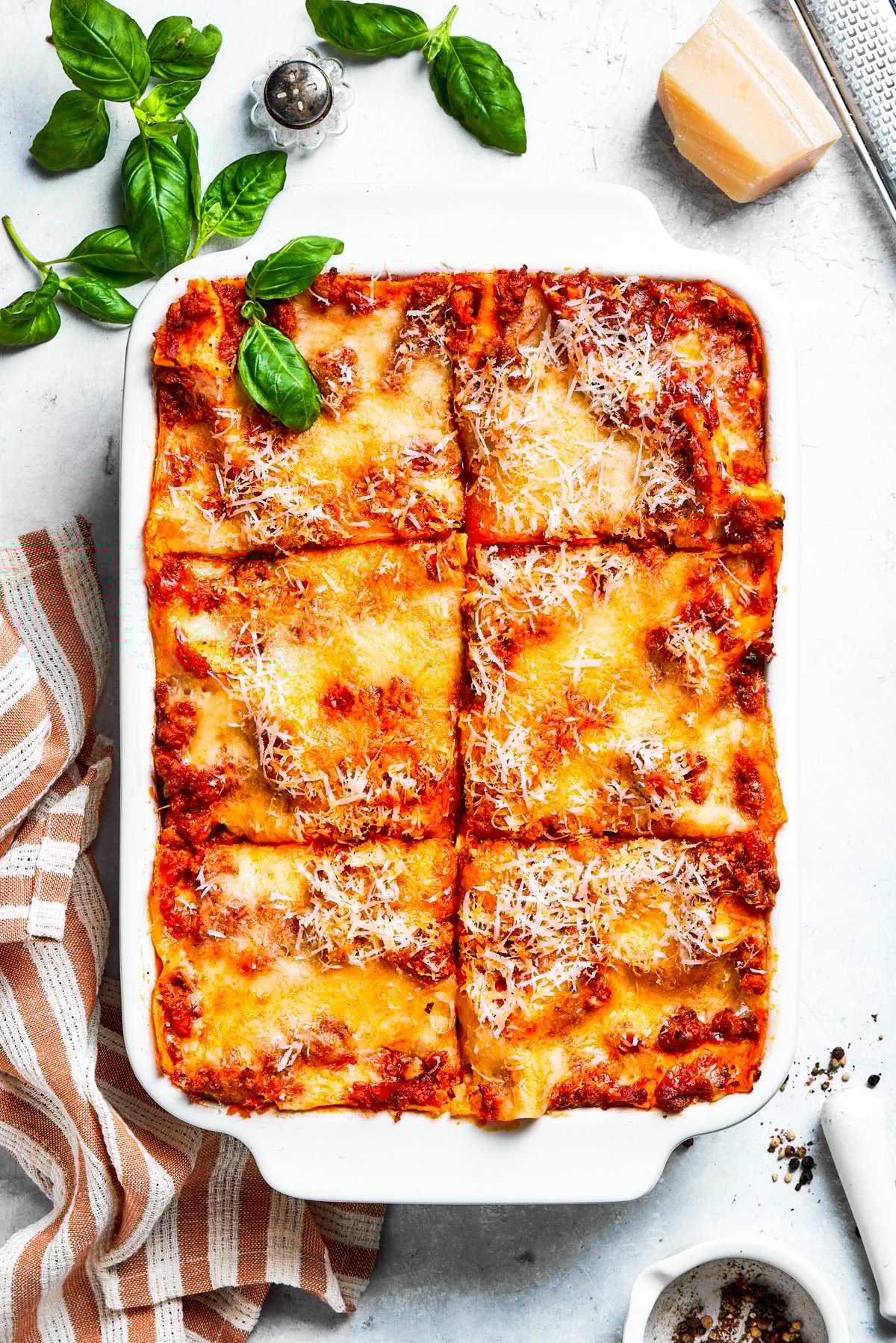 A pan of beef lasagna cut into squares.
