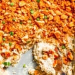 A serving spoon scoops into million dollar chicken casserole.